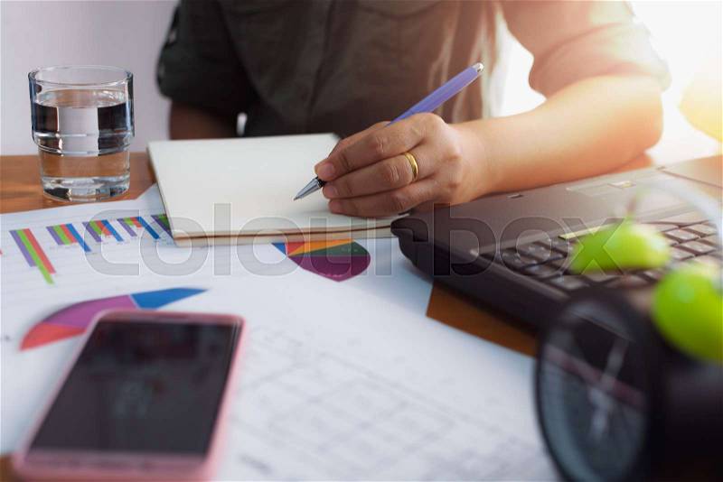 Woman is writing on working desk in office. Business concept, stock photo