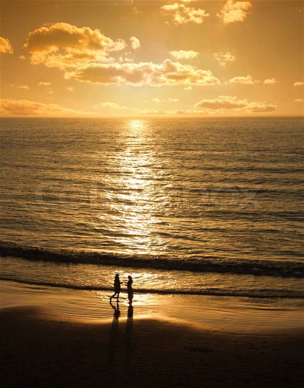 Couple meets at sunset beach, stock photo