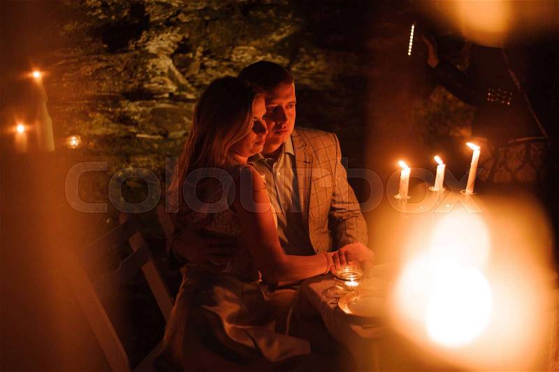 Romantic dinner of a young couple by candlelight in the mountains, stock photo