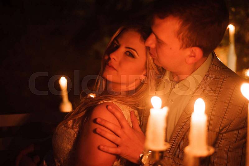 Romantic dinner of a young couple by candlelight in the mountains, stock photo