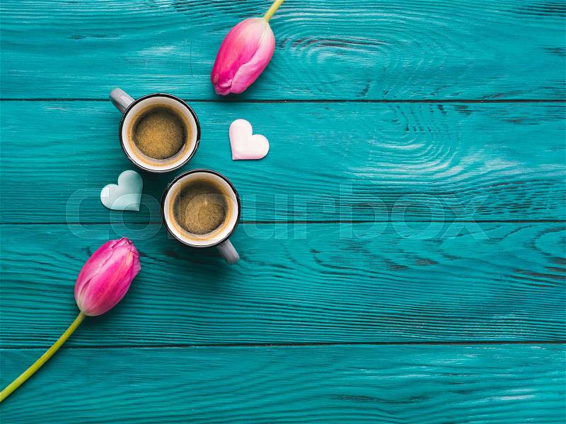 Two cups of coffee, hearts and tulip flowers. Valentine\'s day concept on dark wooden emerald green background, stock photo