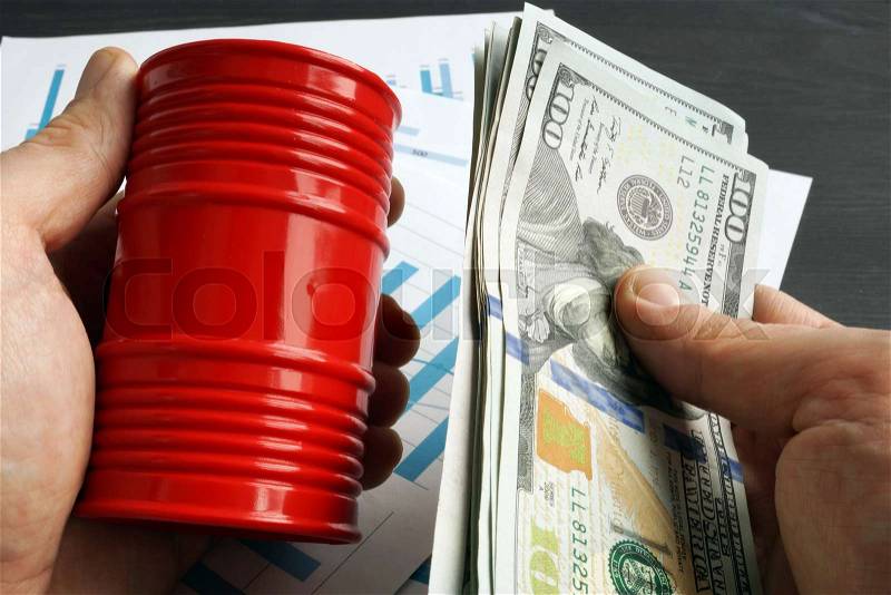 Hands are holding barrel and money. Oil trading, stock photo