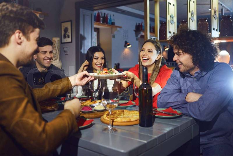 A group of friends eating at a dinner at a meeting in a restaurant, stock photo