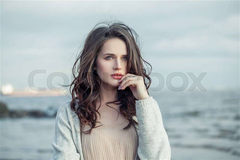 Lovely girl outdoors portrait. Cute female model face on blue water background, stock photo