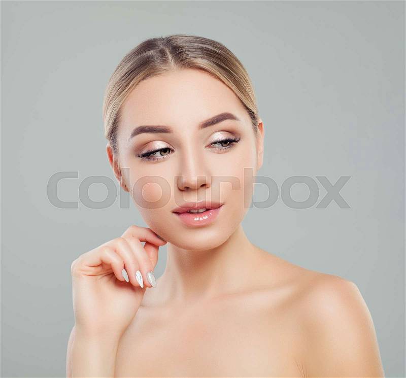 Beautiful young woman with healthy skin looking on copy space on gray background. Facial treatment, skincare and cosmetology concept. , stock photo