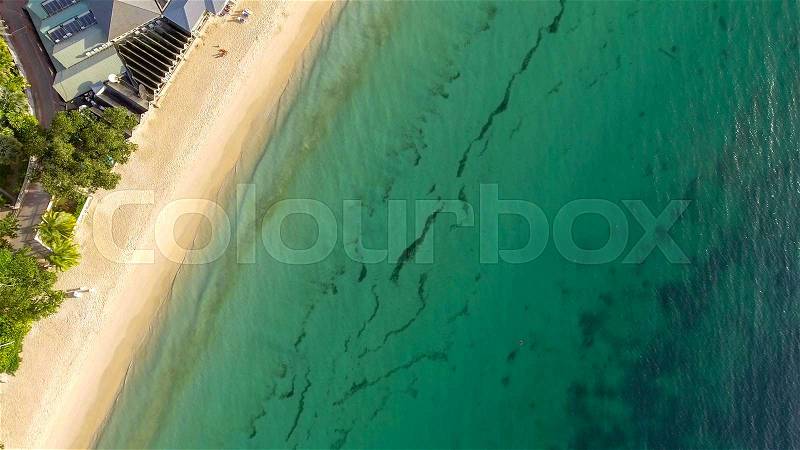 Beautiful aerial overhead view of ocean beach with crystal clear water, stock photo