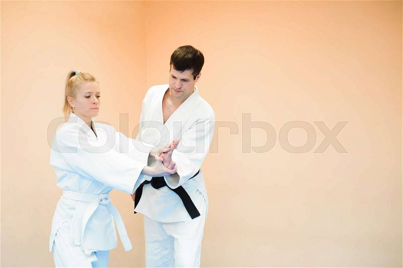 Man and woman fighting at Aikido training in martial arts school, stock photo