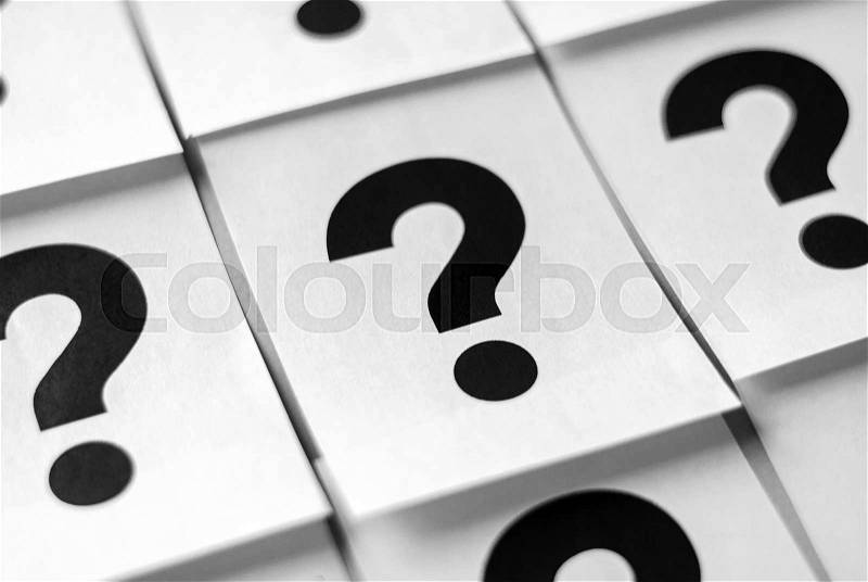 Black question marks printed on white sheets of paper arranged in full frame background concept, stock photo