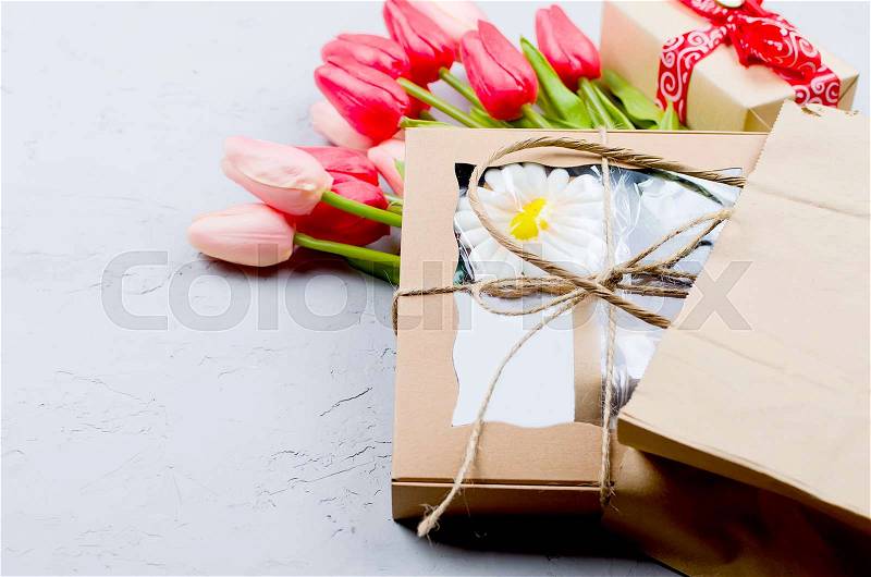 Craft gift box with sweets and cookies and red tulips on old grey background. Valentines day decoration on old background. Copy space. , stock photo