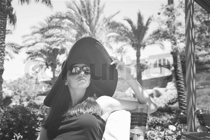 Fashionable girl in the big black hat and sunglasses, stock photo