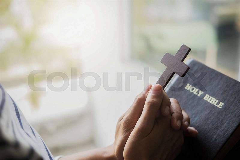 Christian woman praying on holy bible. Hands folded in prayer a holy bible in church concept, stock photo
