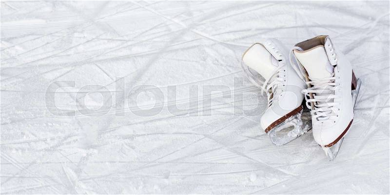 Close up of white figure skates and copy space over ice background with marks from skating or hockey, stock photo