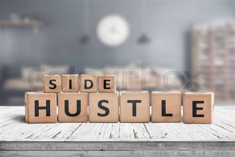Side hustle sign on a plank table in a decorative room with a clock, stock photo