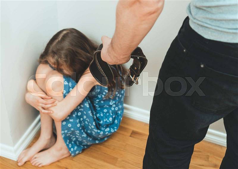 Little girl crying in the corner. Domestic violence concept, stock photo