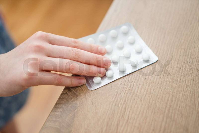 Child takes pack of pills. Dangerous situation, stock photo