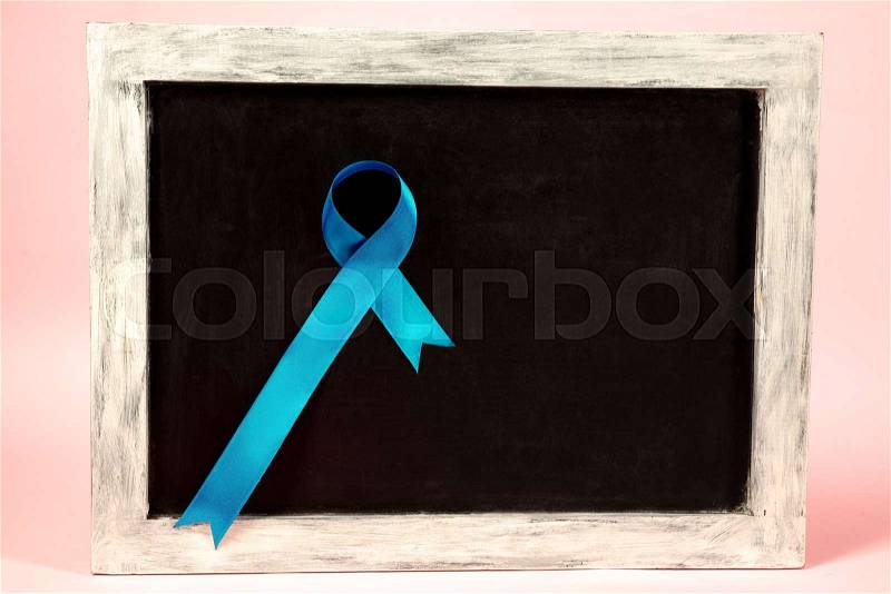 Colon cancer awareness poster. Blue ribbon on black board background. The health, awareness, help, care, support, hope, illness and healthcare concept, stock photo