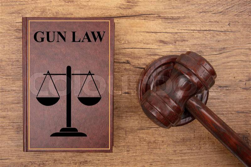 Paragraph Symbol with Gun Law Book on wooden Background, stock photo