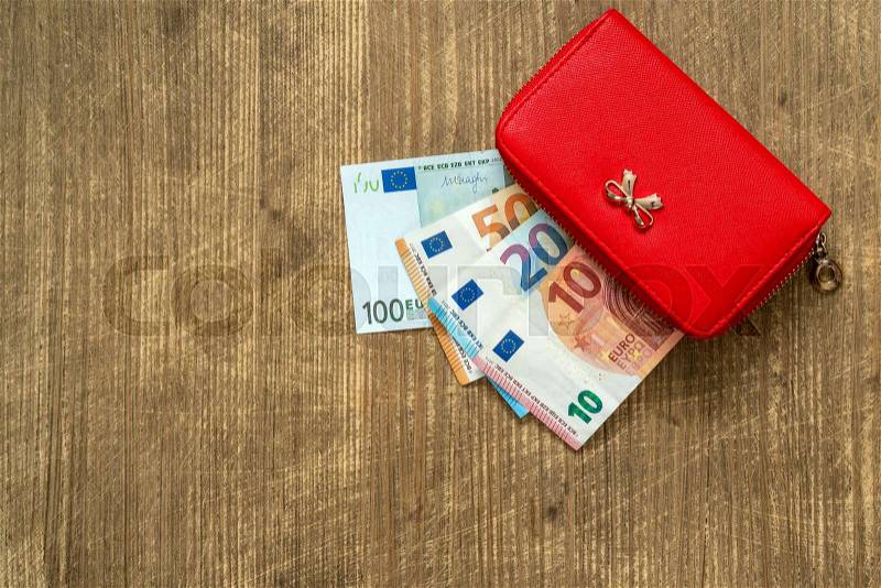 Red female wallet full of euro cash money banknotes. Top view, stock photo