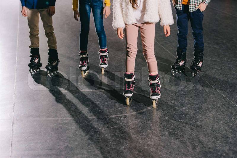 Cropped view of children in roller skates standing in roller rink, stock photo