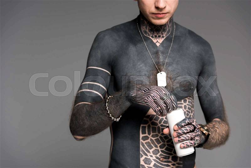 Cropped shot of shirtless tattooed man opening aluminum can isolated on grey, stock photo