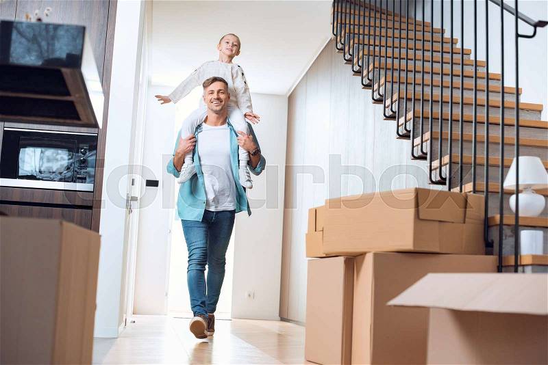 Smiling father carring on neck cute daughter in new home , stock photo