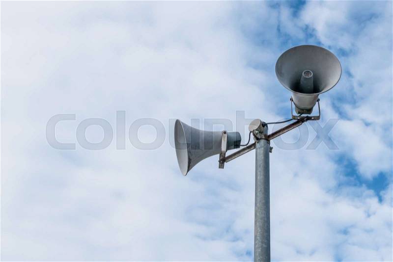 Old loud speakers isolated on the blue sky background with white clouds. Space for text, stock photo