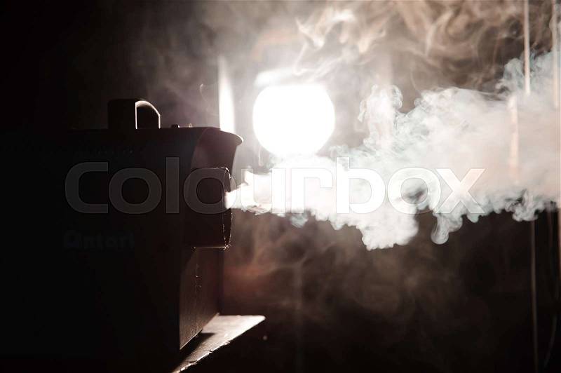 Smoke machine in action in the darkness, stock photo