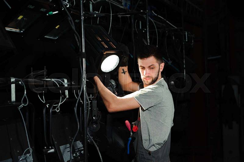 The stage worker sets up the lights on the stage, stock photo