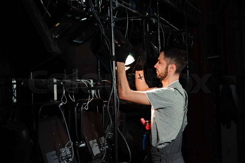 The stage worker sets up the lights on the stage, stock photo