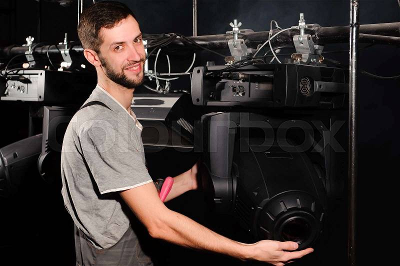 The stage worker sets up the lights, stock photo