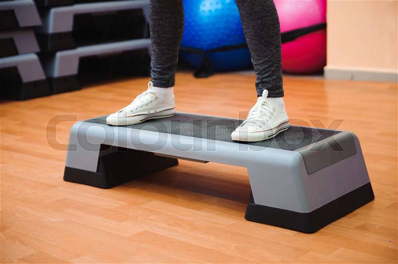 Athletic woman trainer doing aerobic class with steppers. Sport and health concept, stock photo