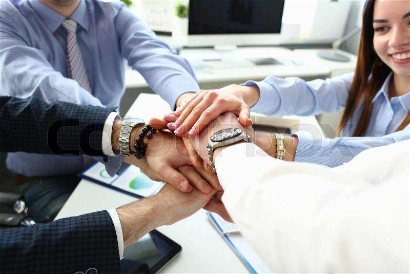 Group of people in suits crossed hands in pile for win closeup. White collar leadership high five cooperation initiative achievement corporate life style friendship ..., stock photo