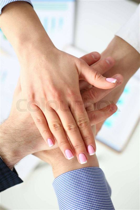 Group of people in suits crossed hands in pile for win closeup. White collar leadership high five cooperation initiative achievement corporate life style friendship ..., stock photo