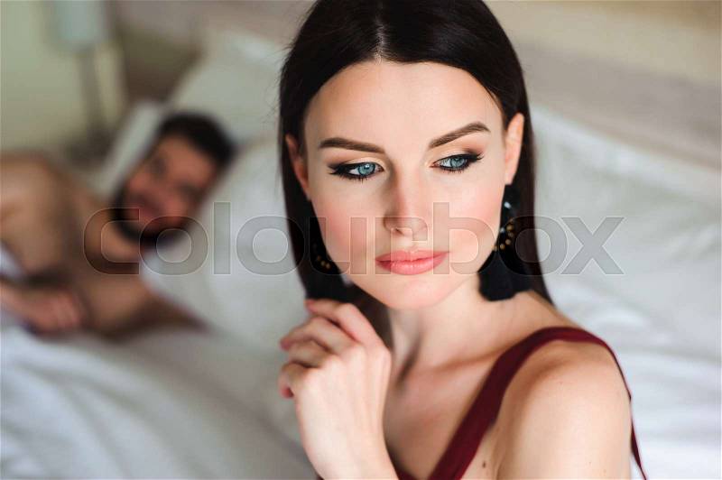 Couple in bed, portrait of a sad woman in bed with her husband, stock photo