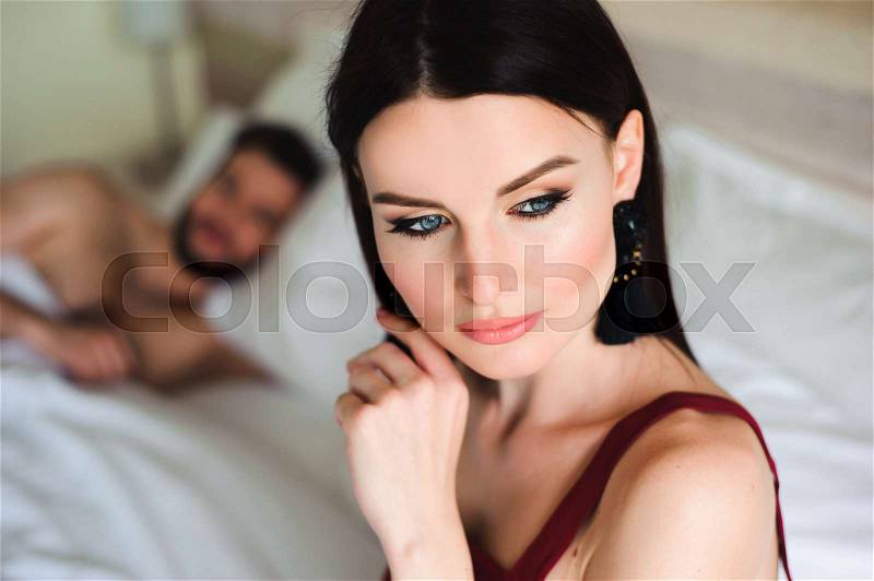 Couple in bed, portrait of a sad woman in bed with her husband, stock photo