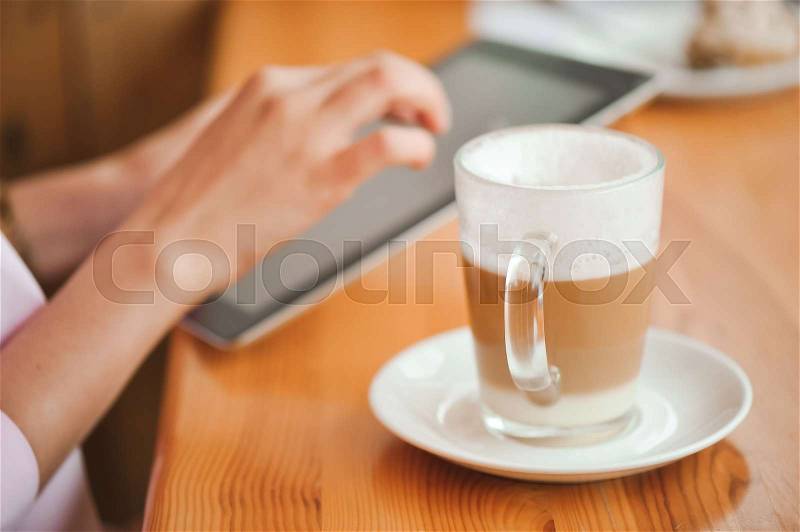 Close up hand woman using tablet in coffee shop, stock photo