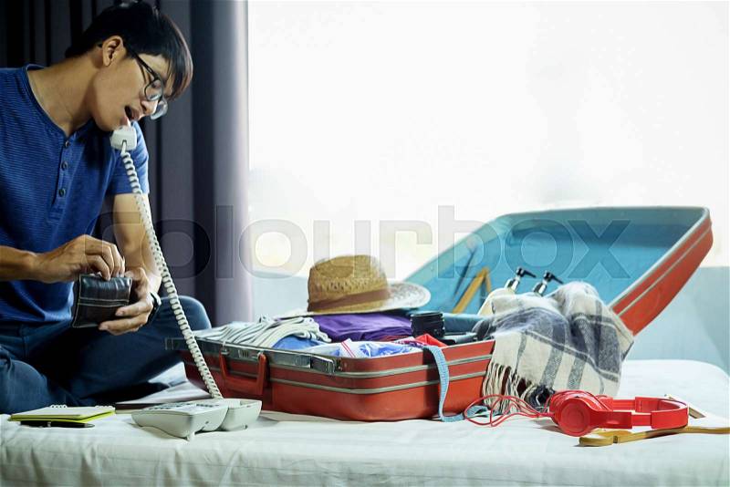 People packed suitcase with travel accessories on bed. Vacation concept, stock photo