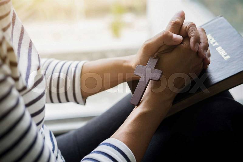 Christian woman praying on holy bible. Hands folded in prayer a holy bible in church concept, stock photo