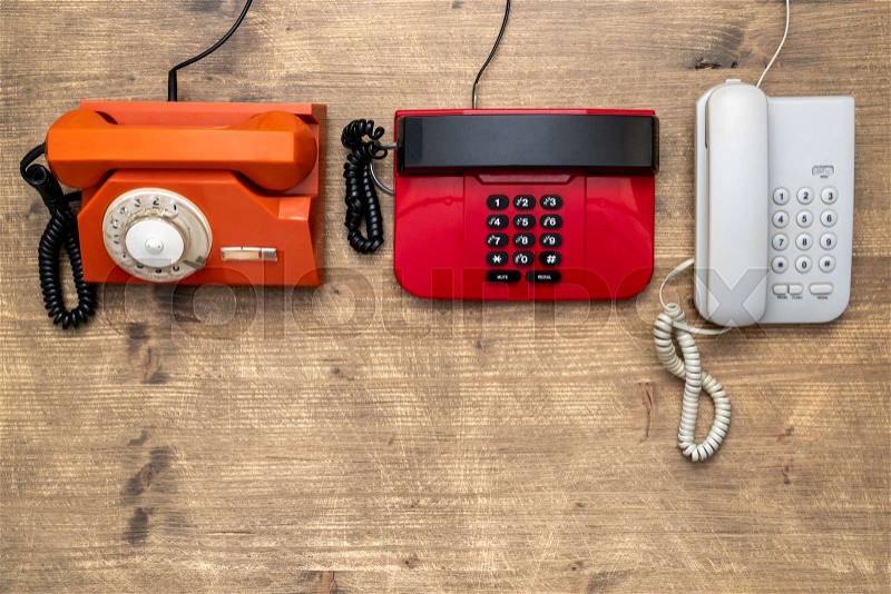 Three old telephones on wooden background. Top view,copy space, stock photo