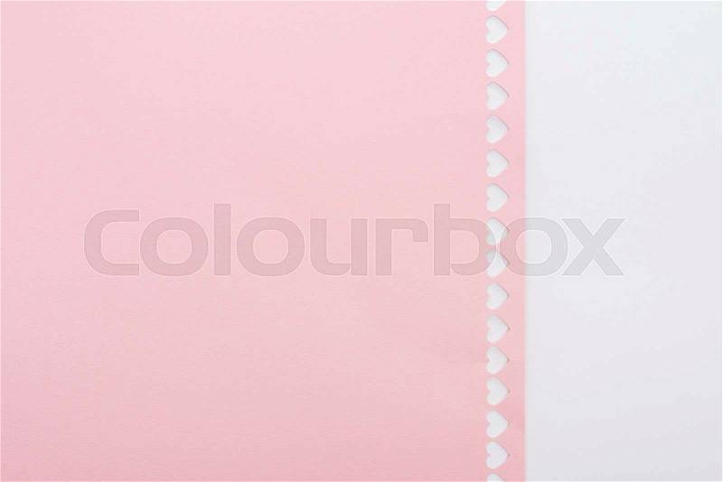 Background of cut out hearts in row on pink paper isolated on white with copy space, stock photo