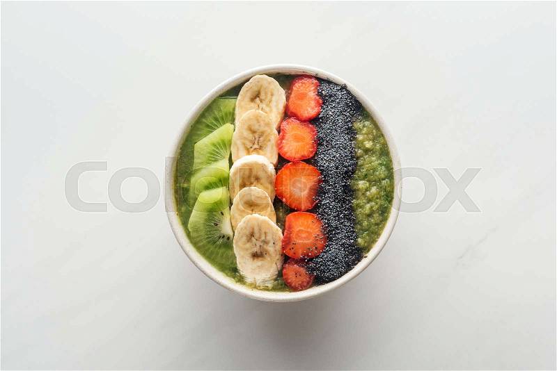 Top view of smoothie bowl with fresh fruits on white background, stock photo