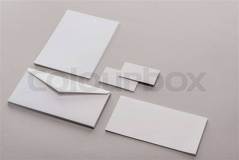 Envelope, cards and sheets of paper on grey background, stock photo