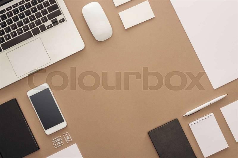 Top view of laptop, smartphone, pen, computer mouse, cards and notebook, stock photo