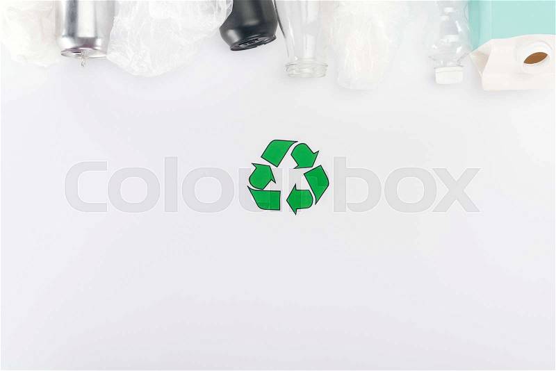 Top view of cans, plastic bags, carton bottle, glass and plastic bottles on white background with recycling sign, stock photo