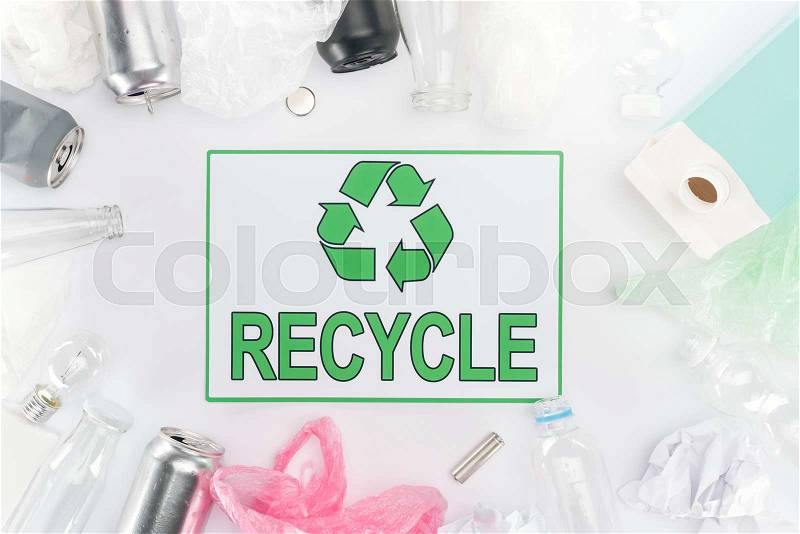 Cans, plastic and glass bottles, batteries, paper, bulb, carton bottle and plastic bags with recycling sign, stock photo