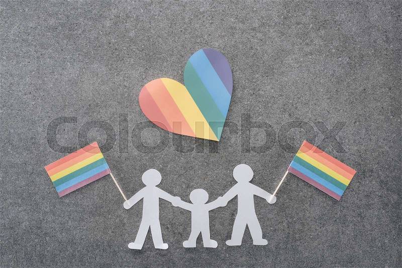 Paper cut same sex family with rainbow colored flags and paper heart on grey background, lgbt concept, stock photo