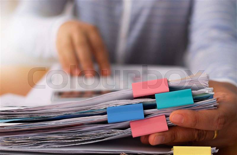 Hands of woman working with stack of paper document to calculate the cost of expenses, Business document concept, stock photo