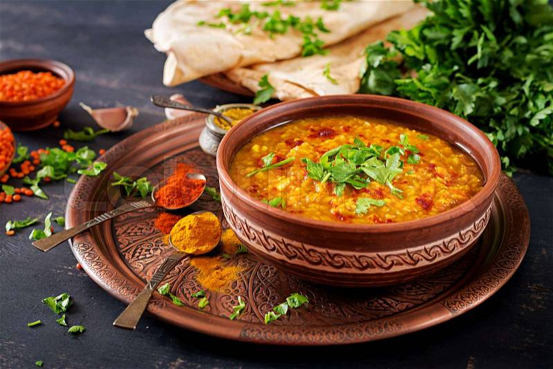 Indian dal. Traditional Indian soup lentils. Indian Dhal spicy curry in bowl, spices, herbs, rustic black wooden background. Authentic Indian dish. Overhead, stock photo