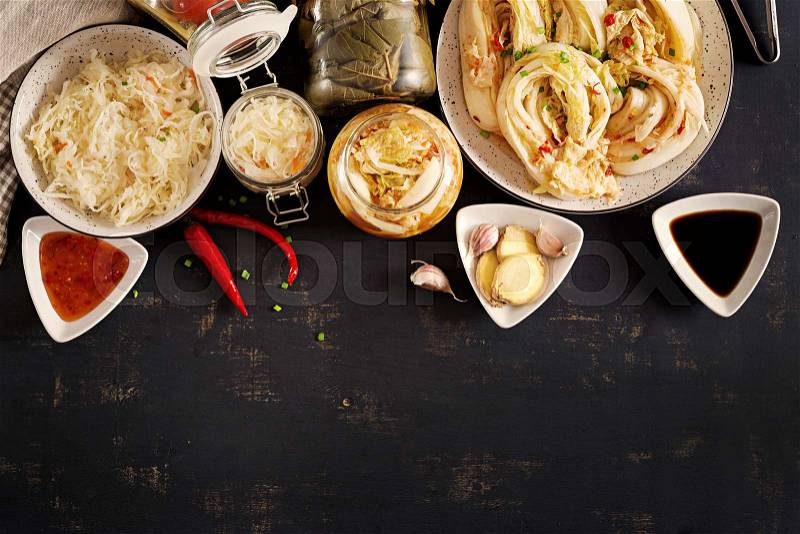 Fermented food. Vegetarian food concept. Cabbage kimchi, tomatoes marinated, sauerkraut sour glass jars over rustic kitchen table. Canned food concept. Top view. ..., stock photo