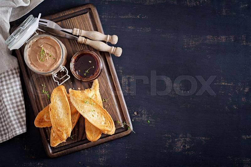 Chicken homemade liver paste or pate in glass jar with toasts and lingonberry jam with chili. Top view, copy space, stock photo